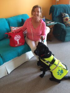 Women with her service dog and bag of books